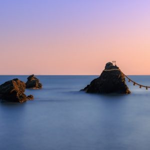 夫婦岩の写真「朝焼けの空と白波の夫婦岩と周辺の岩」