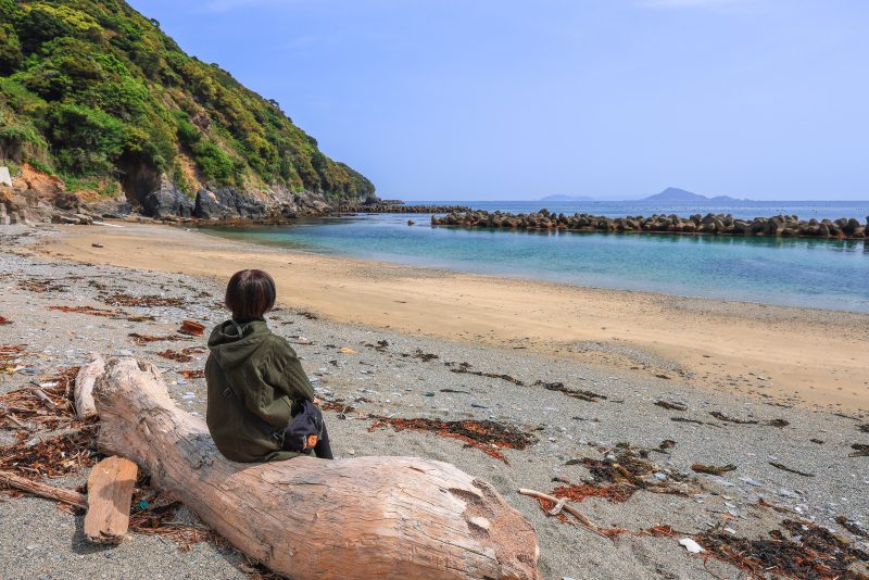 答志島の写真「答志大間の浜の漂流物に座る人」