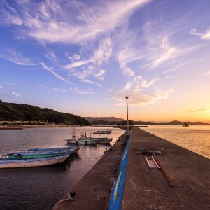 桃取の堤防から眺める夕焼けと停泊する船