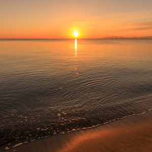 香良洲海岸の写真「穏やかな波打ち際と朝日」