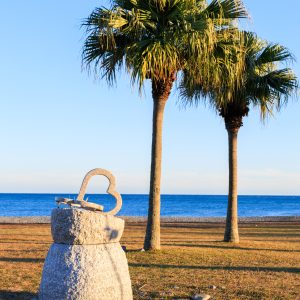 無料スマホ壁紙 ハートのモニュメントとヤシの木が並ぶサンセットビーチ。AndroidとiPhoneに対応した4K高画質の無料待ち受け画像。三重県御浜町の七里御浜ふれあいビーチで撮影したフリー写真素材