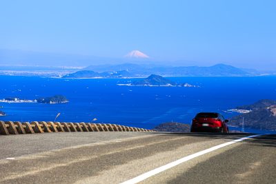 無料壁紙 鳥羽側の道路を走る車と絶景の富士山。PCとデスクトップ壁紙に最適な4K高画質の無料壁紙。三重県伊勢市の伊勢志摩スカイラインで撮影したフリー写真素材