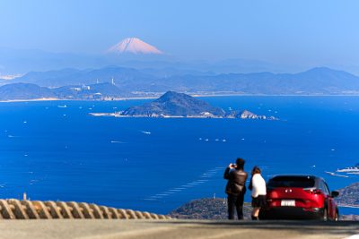 無料壁紙 鳥羽側の道路脇から富士山を眺める人。PCとデスクトップ壁紙に最適な4K高画質の無料壁紙。三重県伊勢市の伊勢志摩スカイラインで撮影したフリー写真素材