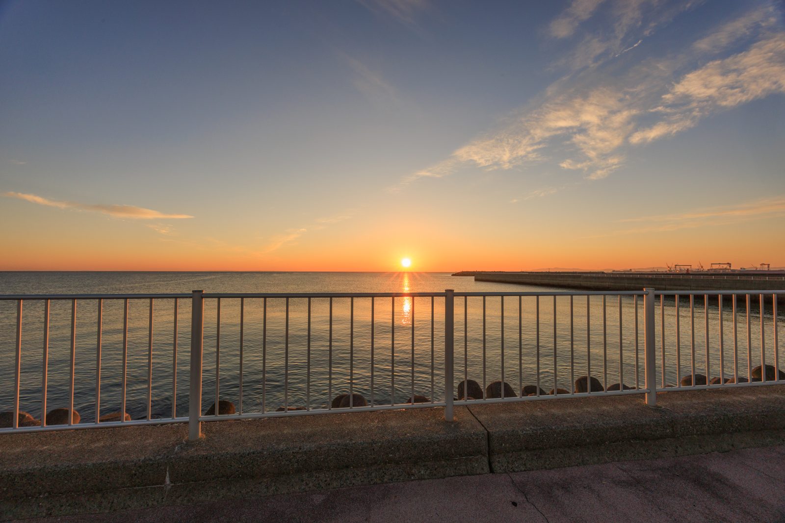 無料壁紙 遊歩道から眺める朝日と津日本鋼管。PCとデスクトップ壁紙に最適な4K高画質の無料壁紙。三重県津市の津エアポートラインで撮影したフリー写真素材