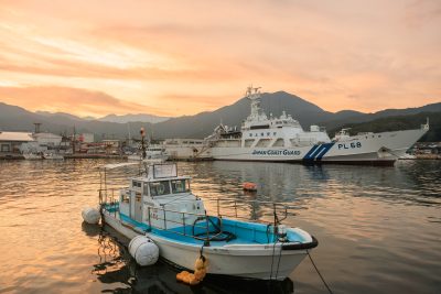 尾鷲港の写真「夕焼けの尾鷲港と巡視船「すずか」と小型船」