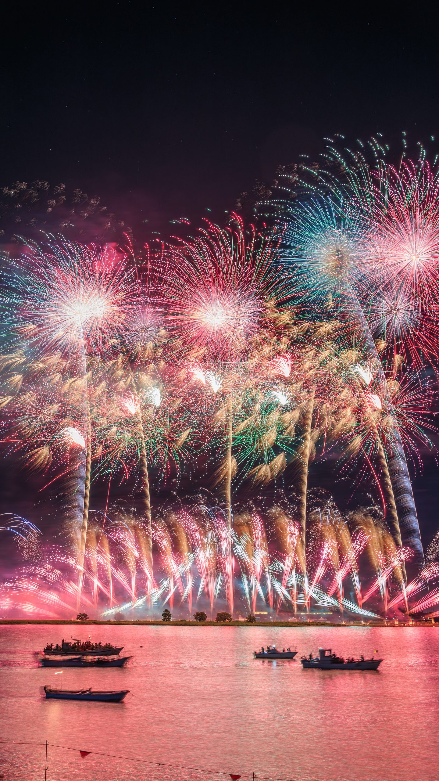 無料スマホ壁紙 ピンクに染まる夜空と揖斐川の花火。AndroidとiPhoneに対応した4K高画質の無料待ち受け画像。三重県桑名市の桑名水郷花火大会で撮影したフリー写真素材