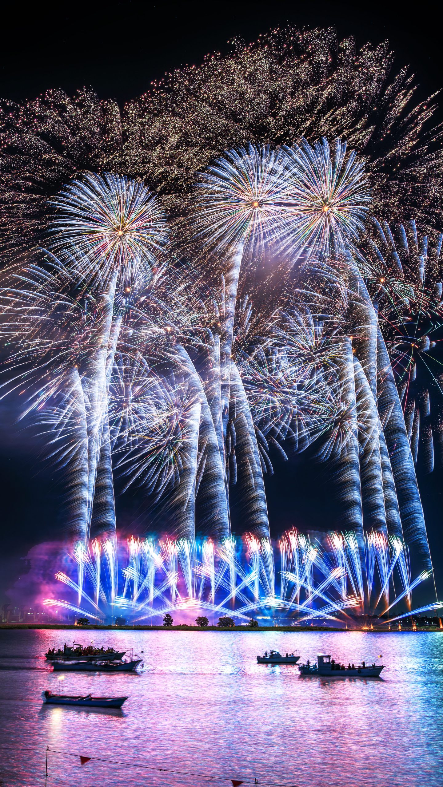 無料スマホ壁紙 青と黄色の連発花火。AndroidとiPhoneに対応した4K高画質の無料待ち受け画像。三重県桑名市の桑名水郷花火大会で撮影したフリー写真素材