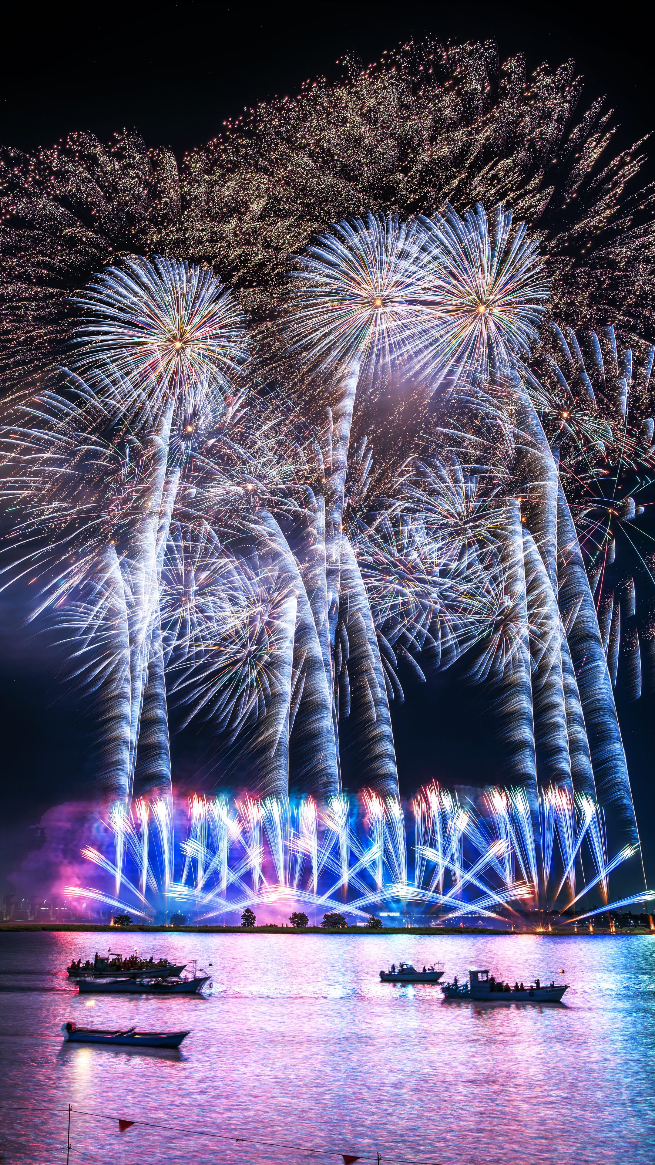 無料スマホ壁紙 青と黄色の連発花火。AndroidとiPhoneに対応した4K高画質の無料待ち受け画像。三重県桑名市の桑名水郷花火大会で撮影したフリー写真素材