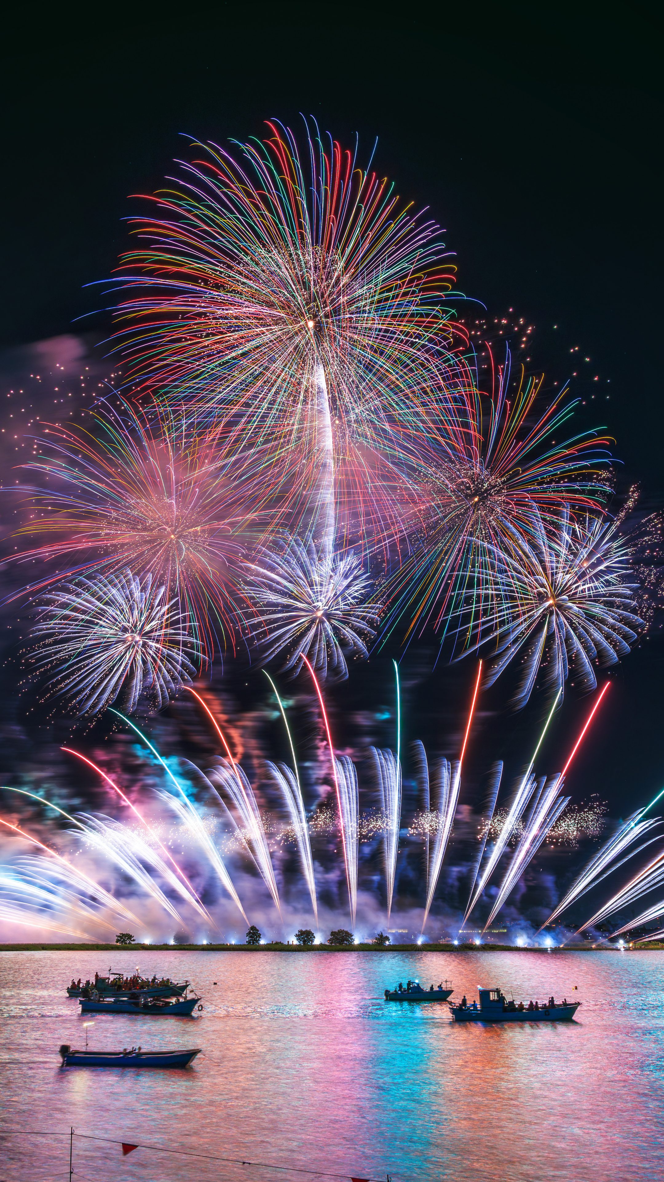 無料スマホ壁紙 レインボーが連なる連発花火。AndroidとiPhoneに対応した4K高画質の無料待ち受け画像。三重県桑名市の桑名水郷花火大会で撮影したフリー写真素材