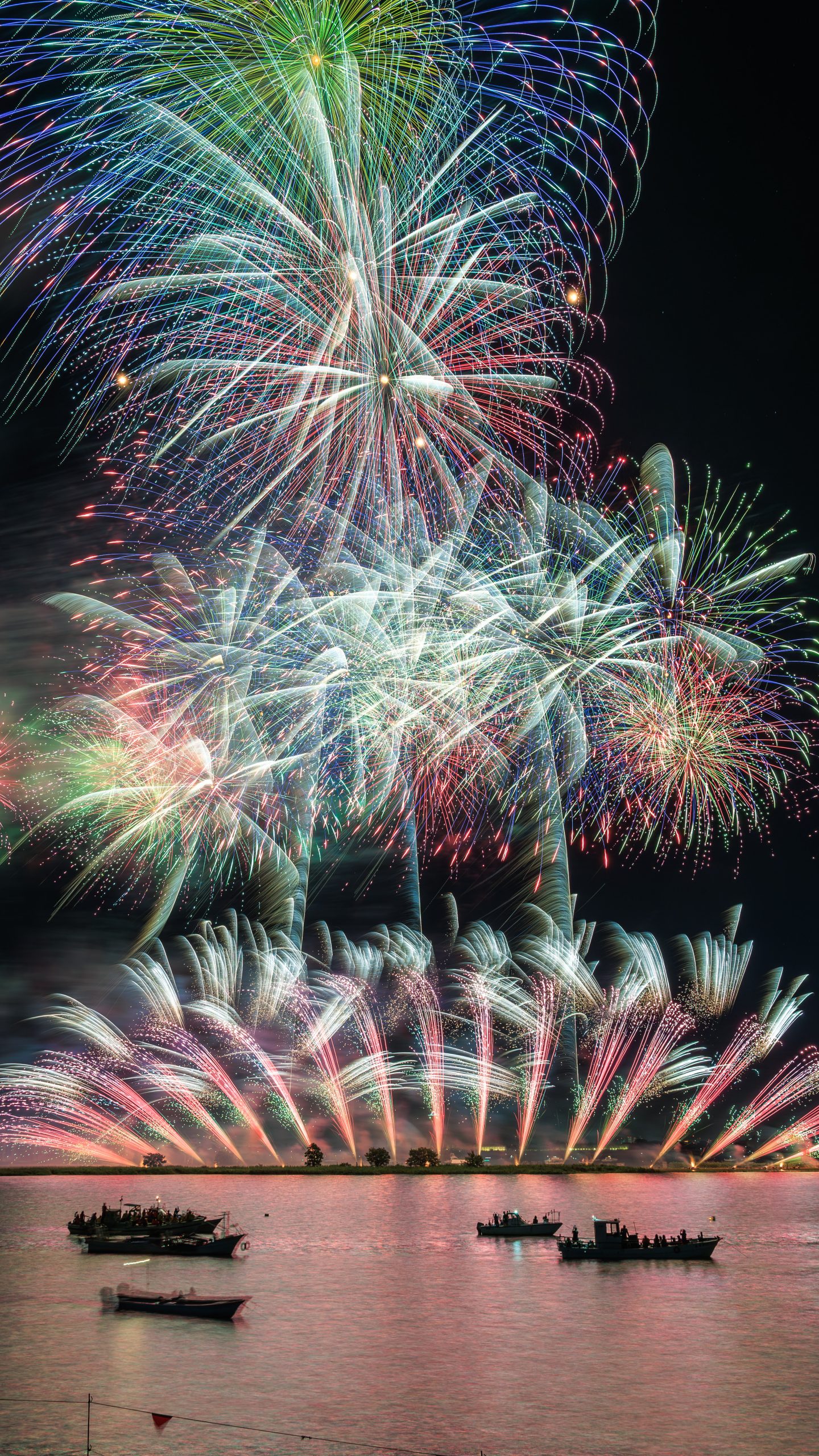無料スマホ壁紙 彩り豊かな連発花火。AndroidとiPhoneに対応した4K高画質の無料待ち受け画像。三重県桑名市の桑名水郷花火大会で撮影したフリー写真素材