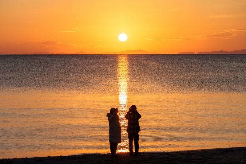 香良洲海岸の写真「朝日を眺める２人」