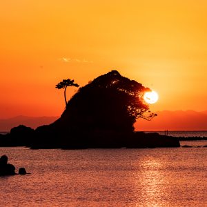 あづり浜の写真「雀島（ゴジラ）の夕焼けパックンチョ」