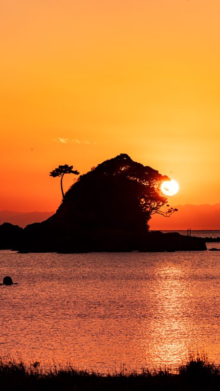 無料スマホ壁紙「雀島（ゴジラ）の夕焼けパックンチョ」
