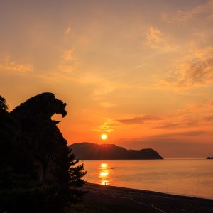 太陽が昇る獅子岩と朝焼けの七里御浜