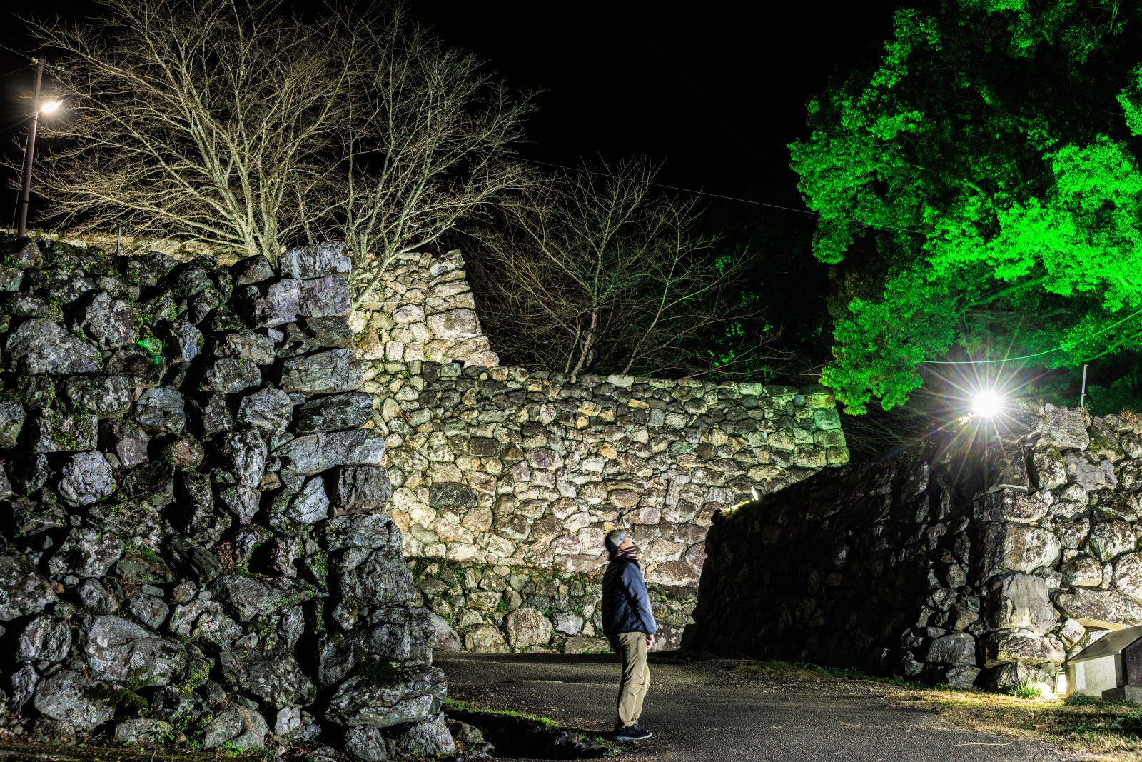 無料壁紙 ライトアップされた石垣を見る男性。PCとデスクトップ壁紙に最適な4K高画質の無料壁紙。三重県玉城町の田丸城跡で撮影したフリー写真素材