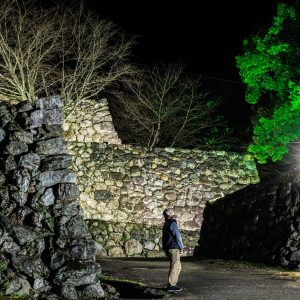 無料壁紙 ライトアップされた石垣を見る男性。PCとデスクトップ壁紙に最適な4K高画質の無料壁紙。三重県玉城町の田丸城跡で撮影したフリー写真素材