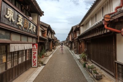 フリー写真素材「レイトロな街道を歩く人」