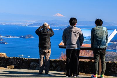 無料壁紙 朝熊山頂の看板付近で富士山を見る人々。PCとデスクトップ壁紙に最適な4K高画質の無料壁紙。三重県伊勢市の伊勢志摩スカイラインで撮影したフリー写真素材