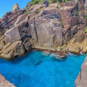 岸壁の間を眺めるオハイブルーの海