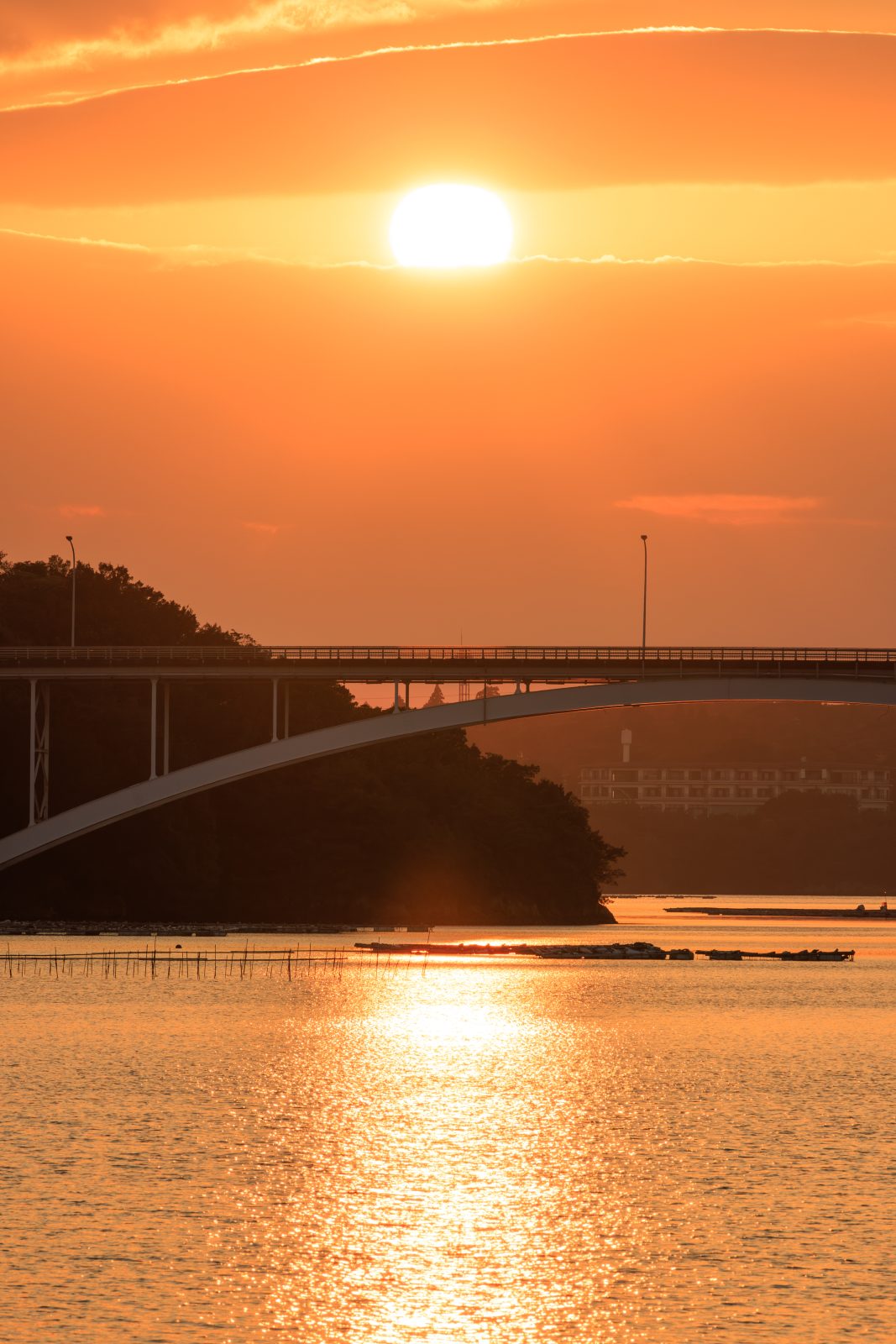 無料スマホ壁紙 賢島大橋と雲の隙間から見える夕陽。AndroidとiPhoneに対応した4K高画質の無料待ち受け画像。三重県志摩市の賢島大橋で撮影したフリー写真素材