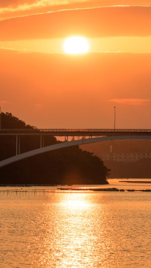 無料スマホ壁紙 賢島大橋と雲の隙間から見える夕陽。AndroidとiPhoneに対応した4K高画質の無料待ち受け画像。三重県志摩市の賢島大橋で撮影したフリー写真素材