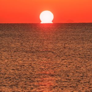 無料スマホ壁紙 真っ赤に染まる「だるま太陽」。AndroidとiPhoneに対応した4K高画質の無料待ち受け画像。三重県津市の津エアポートラインで撮影したフリー写真素材