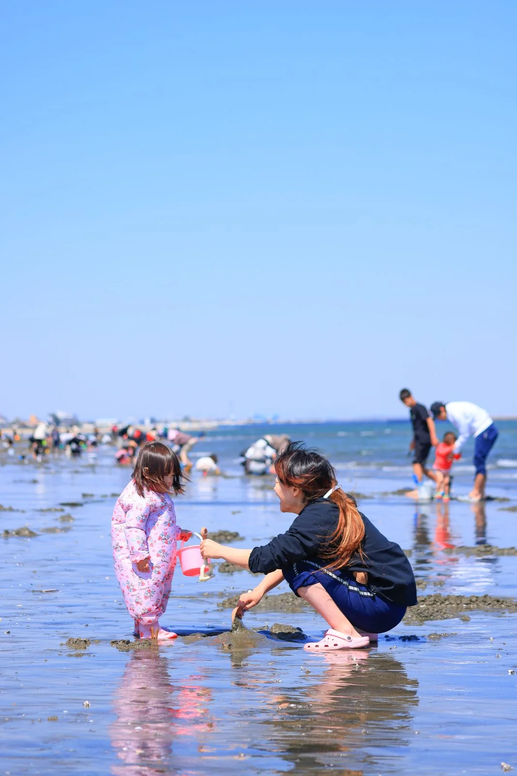 無料スマホ壁紙 潮干狩りを楽しむ親子。AndroidとiPhoneに対応した4K高画質の無料待ち受け画像。三重県津市の御殿場海岸で撮影したフリー写真素材