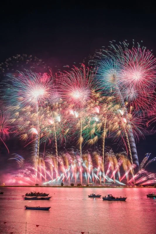 無料スマホ壁紙 ピンクに染まる夜空と揖斐川の花火。AndroidとiPhoneに対応した4K高画質の無料待ち受け画像。三重県桑名市の桑名水郷花火大会で撮影したフリー写真素材