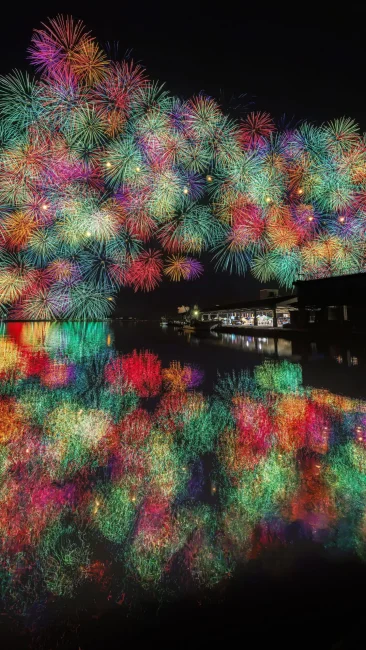 無料スマホ壁紙 アーチを描く虹色の花火。AndroidとiPhoneに対応した4K高画質の無料待ち受け画像。三重県尾鷲市のおわせ港まつりで撮影したフリー写真素材