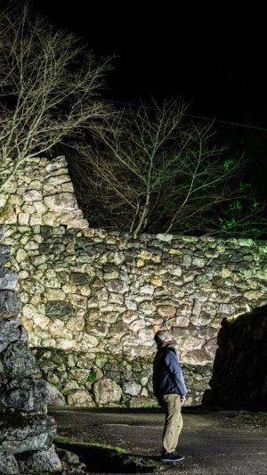 無料壁紙 ライトアップされた石垣を見る男性。PCとデスクトップ壁紙に最適な4K高画質の無料壁紙。三重県玉城町の田丸城跡で撮影したフリー写真素材