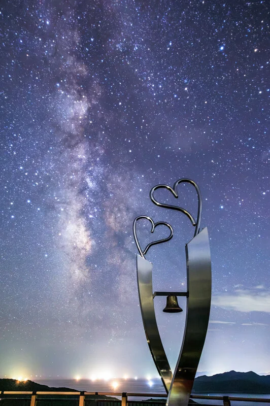 運気が上がる待ち受け 広大な夏の天の川とハートのモニュメント。AndroidとiPhoneに対応した4K高画質の無料スマホ壁紙。三重県南伊勢町の見江島展望台で撮影したフリー写真素材