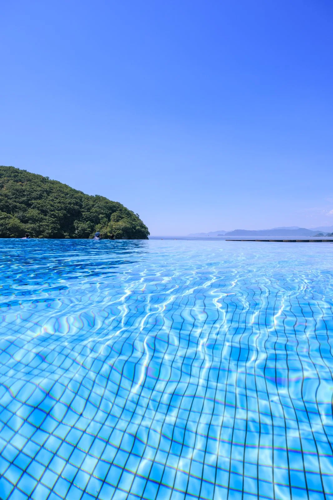 無料スマホ壁紙 インフィニティプール（縦）。AndroidとiPhoneに対応した4K高画質の無料待ち受け画像。三重県紀北町の城ノ浜プール＆ビーチで撮影したフリー写真素材