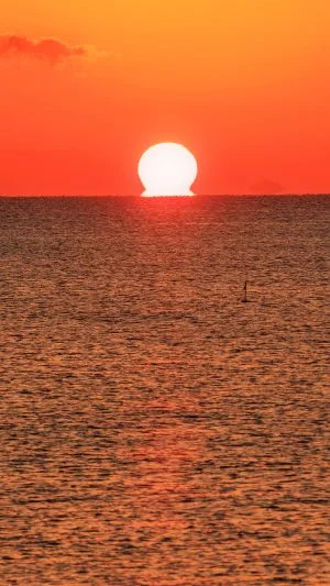 無料スマホ壁紙 真っ赤に染まる「だるま太陽」。AndroidとiPhoneに対応した4K高画質の無料待ち受け画像。三重県津市の津エアポートラインで撮影したフリー写真素材