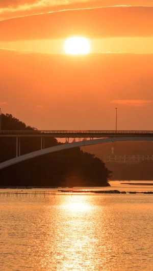 無料スマホ壁紙 賢島大橋と雲の隙間から見える夕陽。AndroidとiPhoneに対応した4K高画質の無料待ち受け画像。三重県志摩市の賢島大橋で撮影したフリー写真素材