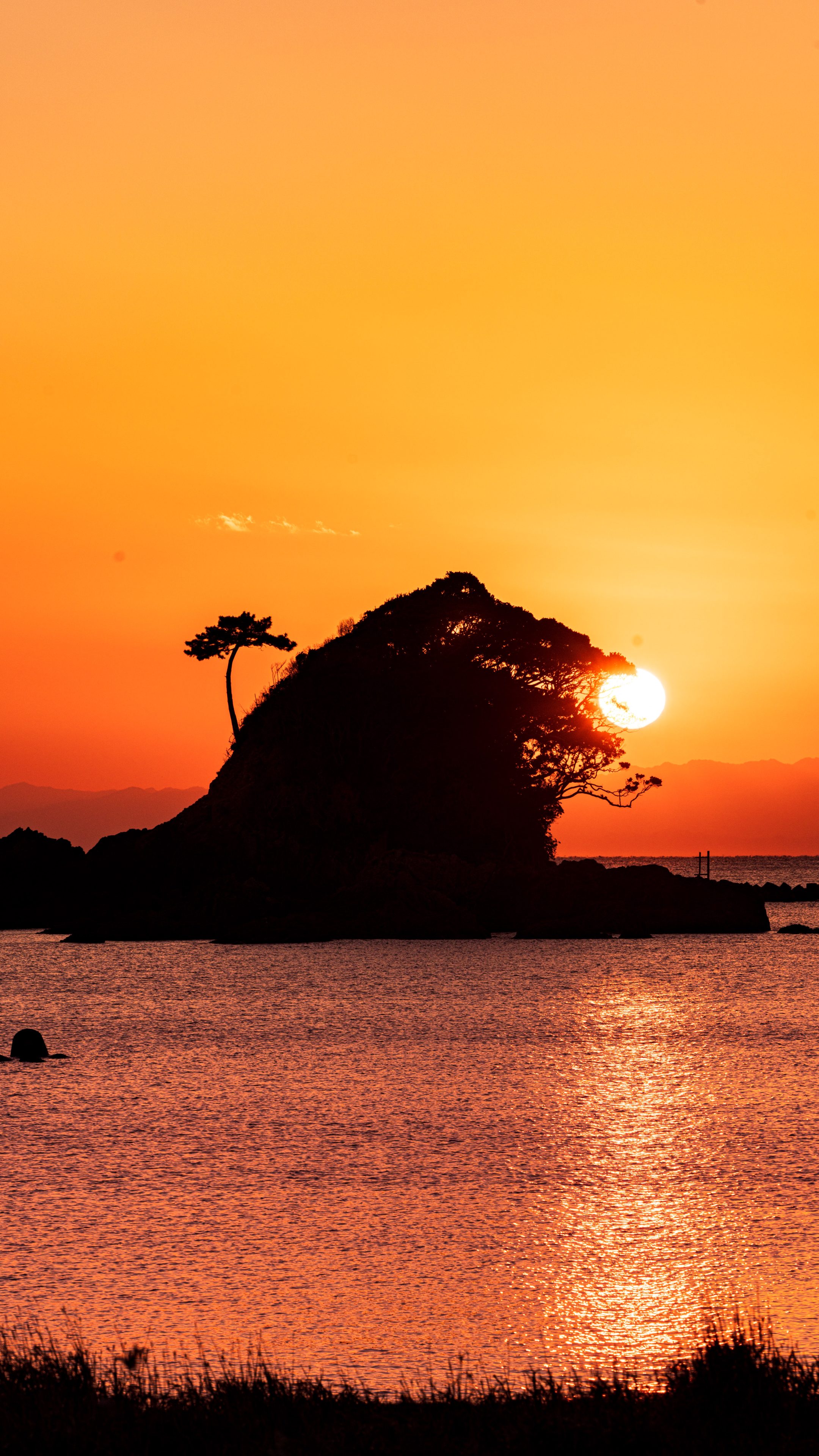無料スマホ壁紙 雀島(ゴジラ)の夕焼けパックンチョ。AndroidとiPhoneに対応した4K高画質の無料待ち受け画像。三重県志摩市のあづり浜で撮影したフリー写真素材