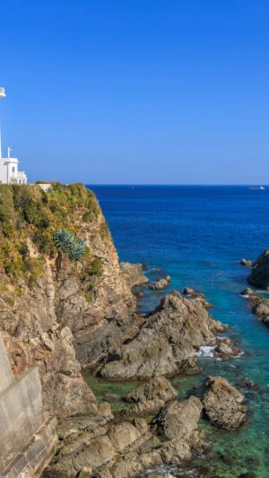 無料壁紙 青い海と澄んだ海の崖に建つ灯台。PCとデスクトップ壁紙に最適な4K高画質の無料壁紙。三重県志摩市の大王埼灯台で撮影したフリー写真素材