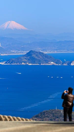 無料壁紙 鳥羽側の道路脇から富士山を眺める人。PCとデスクトップ壁紙に最適な4K高画質の無料壁紙。三重県伊勢市の伊勢志摩スカイラインで撮影したフリー写真素材