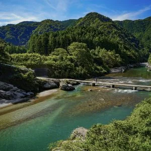 無料壁紙 香肌峡の山々と沈下橋を渡る人。PCとデスクトップ壁紙に最適な4K高画質の無料壁紙。三重県松阪市の香肌峡で撮影したフリー写真素材