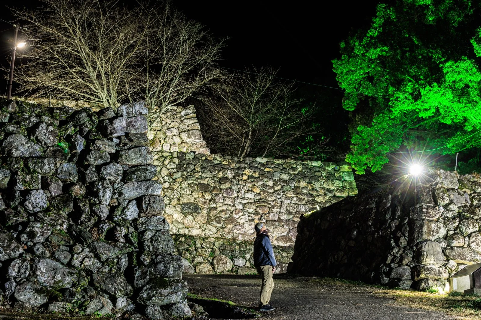 無料壁紙 ライトアップされた石垣を見る男性。PCとデスクトップ壁紙に最適な4K高画質の無料壁紙。三重県玉城町の田丸城跡で撮影したフリー写真素材