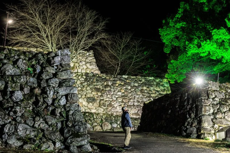 無料壁紙 ライトアップされた石垣を見る男性。PCとデスクトップ壁紙に最適な4K高画質の無料壁紙。三重県玉城町の田丸城跡で撮影したフリー写真素材