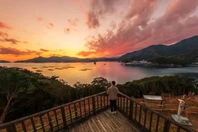 無料壁紙 夕焼けを展望デッキから眺める人。PCとデスクトップ壁紙に最適な4K高画質の無料壁紙。三重県南伊勢町の中ノ磯展望台で撮影したフリー写真素材