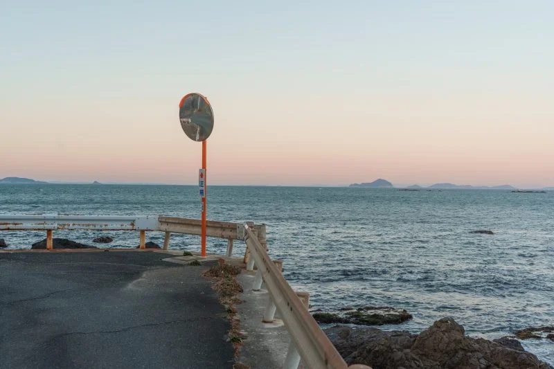 無料壁紙 海沿いの道路から夕焼けを眺める。PCとデスクトップ壁紙に最適な4K高画質の無料壁紙。三重県鳥羽市の石鏡町で撮影したフリー写真素材