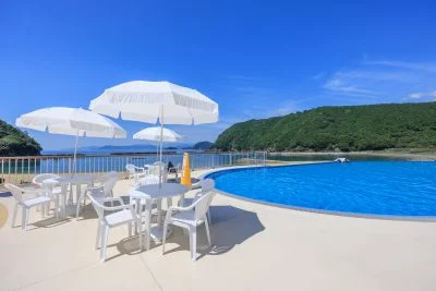 無料壁紙 インフィニティプールの隣にあるパラソル付きテーブル。PCとデスクトップ壁紙に最適な4K高画質の無料壁紙。三重県紀北町の城ノ浜プール＆ビーチで撮影したフリー写真素材