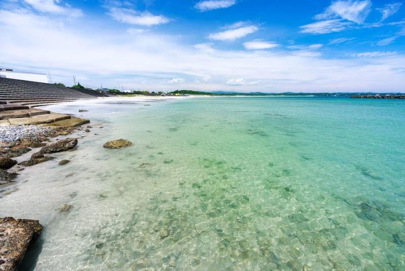 無料壁紙 岩場から海水浴エリアを眺める。PCとデスクトップ壁紙に最適な4K高画質の無料壁紙。三重県志摩市の阿児の松原海水浴場で撮影したフリー写真素材