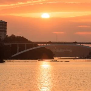 無料壁紙 賢島大橋を走る車と夕陽。PCとデスクトップ壁紙に最適な4K高画質の無料壁紙。三重県志摩市の賢島大橋で撮影したフリー写真素材