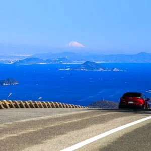 無料壁紙 鳥羽側の道路を走る車と絶景の富士山。PCとデスクトップ壁紙に最適な4K高画質の無料壁紙。三重県伊勢市の伊勢志摩スカイラインで撮影したフリー写真素材