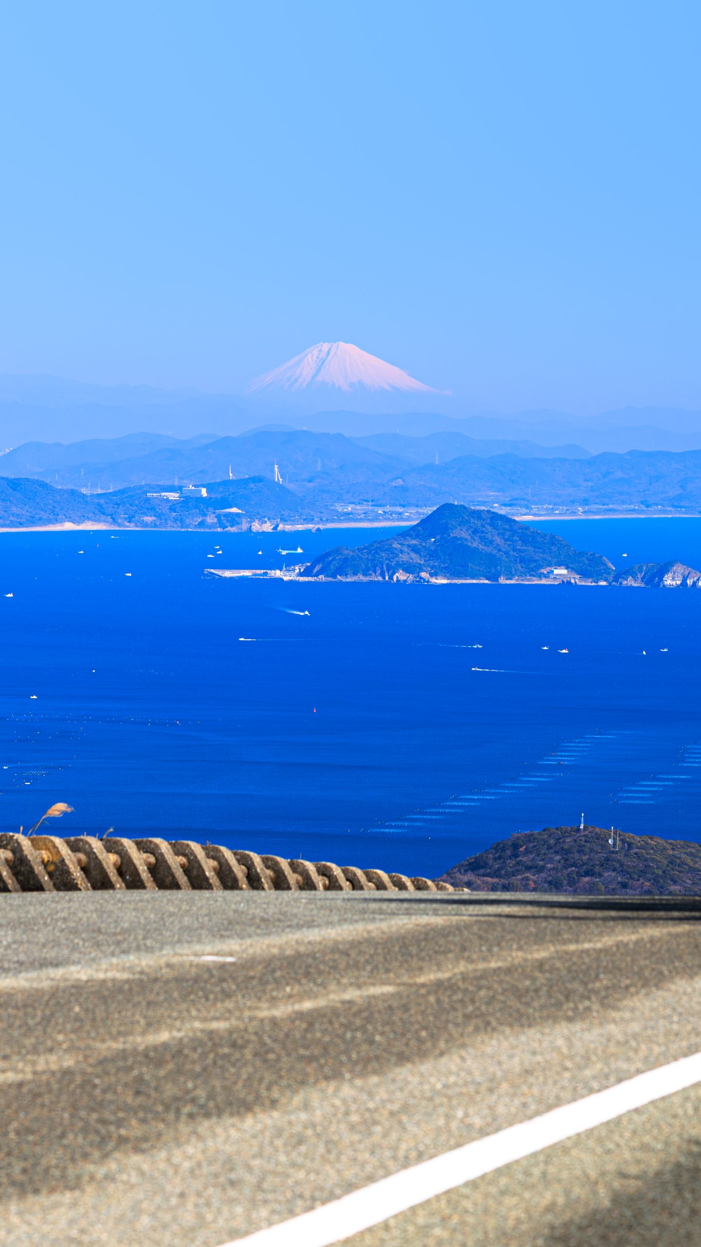 無料壁紙 鳥羽側の道路を走る車と絶景の富士山。PCとデスクトップ壁紙に最適な4K高画質の無料壁紙。三重県伊勢市の伊勢志摩スカイラインで撮影したフリー写真素材