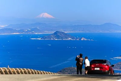 無料壁紙 鳥羽側の道路脇から富士山を眺める人。PCとデスクトップ壁紙に最適な4K高画質の無料壁紙。三重県伊勢市の伊勢志摩スカイラインで撮影したフリー写真素材