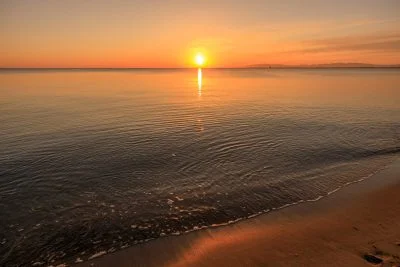 無料壁紙 穏やかな波打ち際と朝日。PCとデスクトップ壁紙に最適な4K高画質の無料壁紙。三重県津市の香良洲海岸で撮影したフリー写真素材