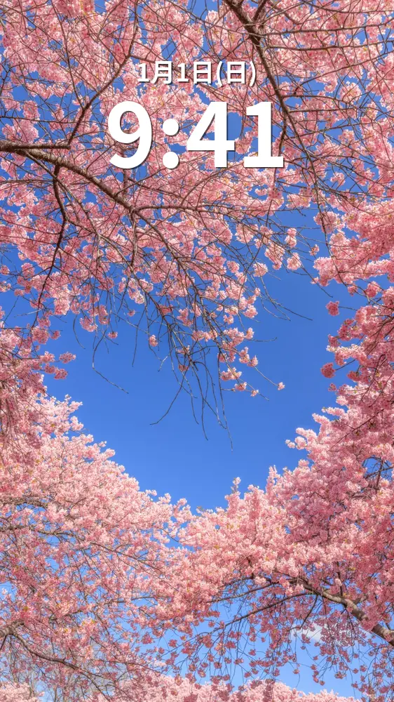 無料スマホ壁紙 青空のハートが浮かぶ河津桜。AndroidとiPhoneに対応した4K高画質の無料待ち受け画像。三重県桑名市のなばなの里で撮影したフリー写真素材